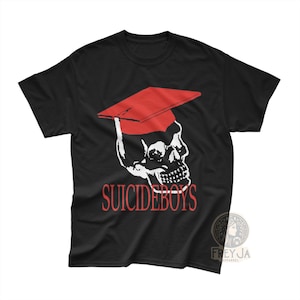 May include: Black t-shirt with a white skull wearing a red mortarboard. The text "SUICIDEBOYS" is printed in red below the skull. The shirt has a crew neck and short sleeves.