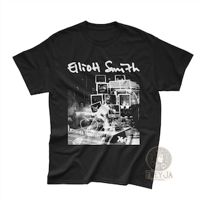 Könnte beinhalten: Schwarzes T-Shirt mit einem weißen Grafikdruck von Elliott Smith. Die Grafik zeigt eine Collage aus Fotos und Text.
