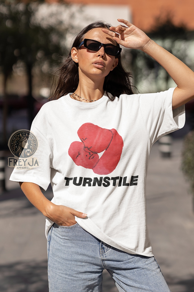 May include: White t-shirt with a red graphic of two boxing gloves and the word "TURNSTILE" printed in black.