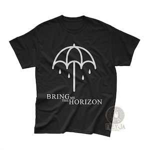 以下が含まれることがあります： 白い傘のデザインと水滴、そして「BRING ME THE HORIZON」の文字がプリントされた黒いTシャツ。クラシックなクルーネックです。