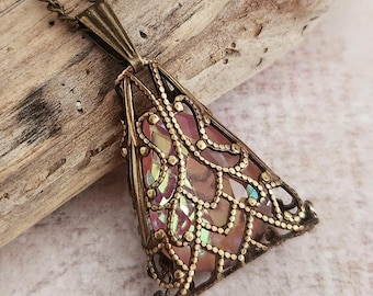 May include: A vintage-style pendant necklace with a triangular, openwork bronze-toned frame. The frame is filled with iridescent, pink, and gold-colored glass pieces. The necklace chain is also bronze-toned.
