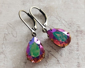 May include: A pair of teardrop-shaped earrings with iridescent, multi-colored crystals. The crystals display hues of pink, purple, green, and orange. The earrings have a lever-back closure and a bronze-colored metal setting.