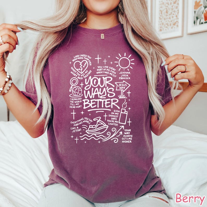 Op de afbeelding: Bessenkleurig T-shirt met de witte tekst "Your Way's Better", vergezeld van diverse afbeeldingen en zinnen. Het ontwerp bevat een hart, een zon, een jetski en andere symbolen. Het T-shirt heeft een ronde hals.