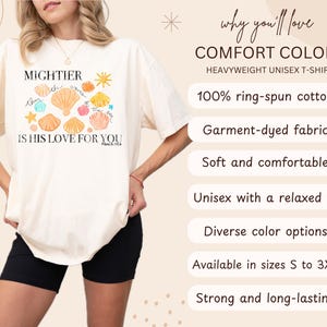 K&ouml;nnte beinhalten: Cremefarbenes, schweres Unisex-T-Shirt mit dem Text "MIGHTIER IS HIS LOVE FOR YOU" und einer Muschel-Grafik. Das Shirt tr&auml;gt auch den Text "PSALM 93:4". Das Shirt besteht aus 100 % ringgesponnener Baumwolle und ist in den Gr&ouml;&szlig;en S bis 3XL erh&auml;ltlich.