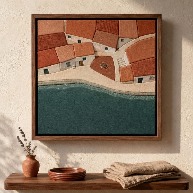 May include: Textured artwork of a coastal village with red-tiled roofs, white buildings, and a teal sea. The artwork is framed in a dark wood. A small brown vase with lavender and a wooden shelf with a bowl and folded cloth are in the foreground.
