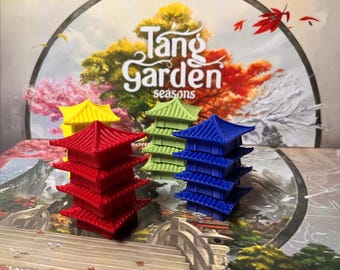 May include: A board game titled "Tang Garden Seasons" featuring colorful pagoda-shaped game pieces in red, yellow, green, and blue. The background shows a scenic illustration of a garden with autumn foliage.