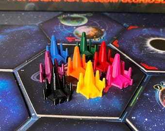 May include: A selection of colorful game pieces in various colors, including black, purple, blue, orange, green, red, pink, and yellow. The pieces are shaped like stylized spaceships and are arranged on a board game with a space theme. The game's title, "PAX MAGNIFICA BELLUM GLORIOSU", is visible.