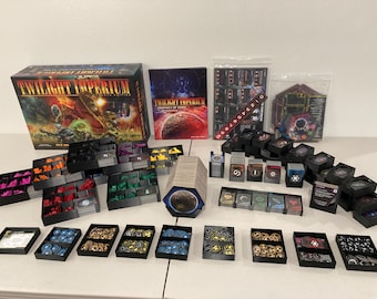 May include: A board game set, "Twilight Imperium", with various components. The box art features a space battle scene. Included are rule books, cards, game pieces, and storage trays. The game pieces are in various colors, including pink, orange, green, and blue.