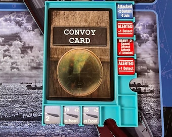 May include: A board game component featuring a "Convoy Card" with a radar image and text. The card is set in a teal plastic holder with additional game elements and text labels. The background shows illustrations of ships and submarines.