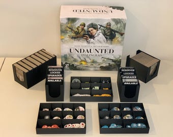 May include: A board game titled "Undaunted: Stalingrad" with various game components. The box art features soldiers and tanks. Includes black storage trays for cards and game pieces, with text reading "RESERVES LOCKED UPGRADES AVAILABLE".