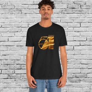 May include: A black t-shirt with a gold graphic of the number 54 with the word "Studio" above it.