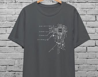 May include: A dark grey t-shirt with a white graphic of a circuit board design. The design features a central processor with lines extending outward.