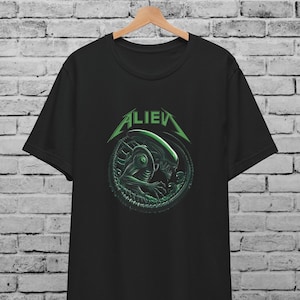 May include: Black t-shirt with a green graphic of an alien creature in a circle with the word "ALIEN" above it.