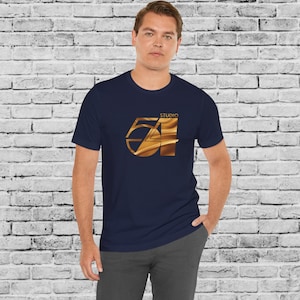 May include: A navy blue t-shirt with a gold metallic graphic of the number 54 and the word "Studio" above it.