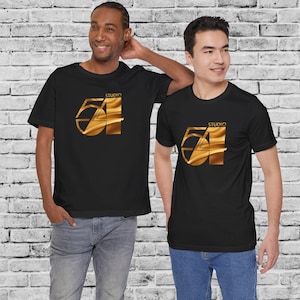 May include: Two people wearing black t-shirts with a gold graphic of the number 54 and the word "Studio" above it. The graphic has a metallic sheen.