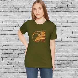 May include: A woman wearing a green t-shirt with a gold graphic of the number 54 with the word "Studio" above it.