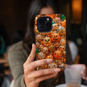 May include: A black iPhone case with a pattern of gold and orange jack-o'-lantern ornaments.