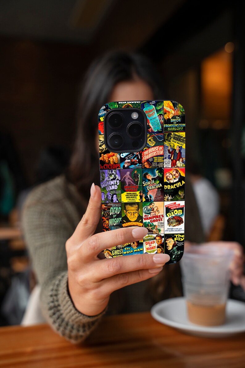 Puede incluir: Una funda de tel&eacute;fono negra con un collage de carteles de pel&iacute;culas de terror vintage. Los carteles incluyen t&iacute;tulos como "La novia de Frankenstein", "El hijo de Dr&aacute;cula", "The Blob" y "El fantasma y el hombre lobo".