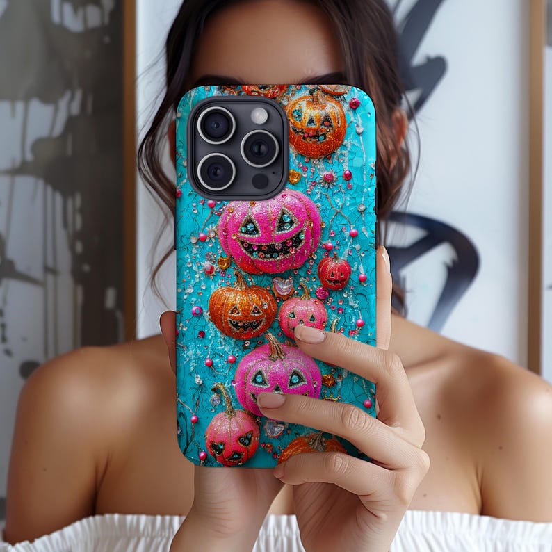 May include: A turquoise phone case featuring a pattern of orange and pink Halloween pumpkins with smiling faces. The pumpkins are decorated with glitter and jewels. The case has a glossy finish and a camera cutout.