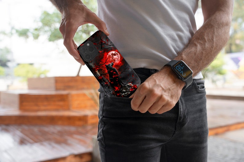 May include: A black phone case with a black cat silhouette against a red moon and a dark forest background.