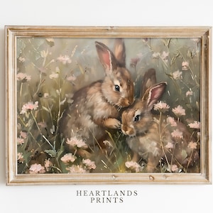 May include: A framed painting of two brown rabbits in a field of pink flowers. The rabbits are looking at each other and the background is a soft green and brown.