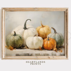 May include: A still life painting of a group of pumpkins in various shades of white, green, and orange. The pumpkins are arranged on a table with a light brown background.
