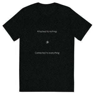 May include: A dark heather grey t-shirt with the text "Attached to nothing" and "Connected to everything" in white. The Om symbol is centered between the two lines of text.