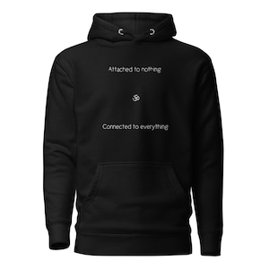 May include: Black hooded sweatshirt with the text "Attached to nothing" and "Connected to everything" in white, with an Om symbol in between.