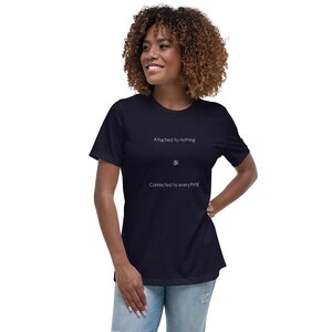 May include: Navy blue t-shirt with white text that reads "Attached to nothing", an Om symbol, and "Connected to everything". The shirt is a relaxed fit and made of soft material.