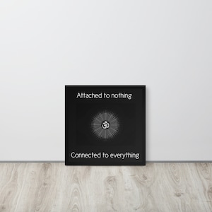 May include: Black and white framed print with the text "Attached to nothing" and "Connected to everything" and a stylized Om symbol in the center.