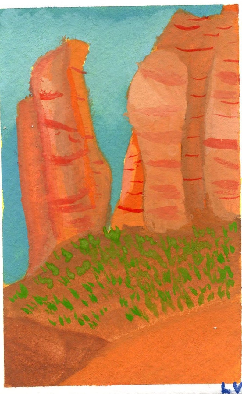 May include: Watercolor painting of a desert landscape featuring tall, reddish-orange rock formations against a light blue sky. Green foliage accents the base of the formations, with a brown foreground.