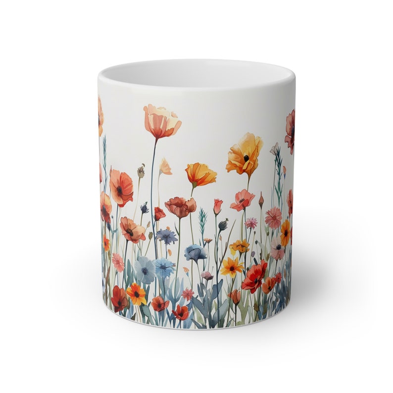 a white coffee mug with colorful flowers painted on it
