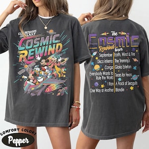 May include: A charcoal gray t-shirt featuring a colorful graphic of Disney characters in a spaceship with the text Guardians of the Galaxy Cosmic Rewind. The back displays a tour list of songs and artists including Earth, Wind & Fire and Blondie.