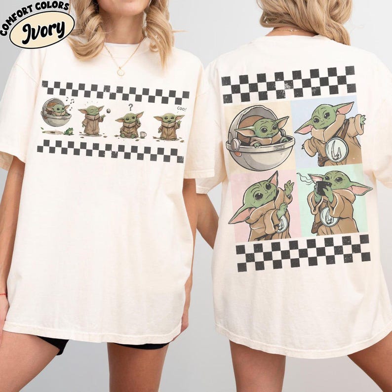 May include: Ivory-colored t-shirt featuring a series of cartoon images of a green alien character. The front of the shirt has a black and white checkered border. The back of the shirt has four images of the same character with a checkered border.