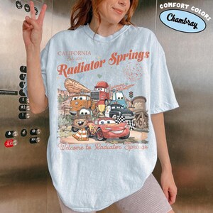 レトロなラジエータースプリングスのコンフォートカラーシャツ、ライトニング・マックィーンのディズニーTシャツ、ピクサーカーズのファミリーシャツ、メーターのTシャツ、ディズニーバケーションTシャツ Chambray/Light Blue