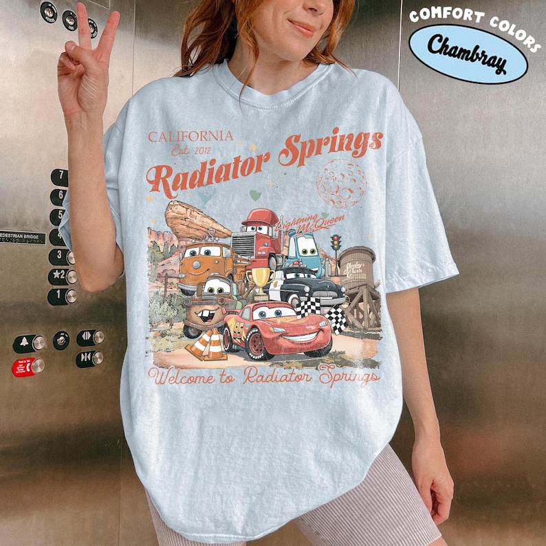 レトロなラジエータースプリングスのコンフォートカラーシャツ、ライトニング・マックィーンのディズニーTシャツ、ピクサーカーズのファミリーシャツ、メーターのTシャツ、ディズニーバケーションTシャツ Chambray/Light Blue