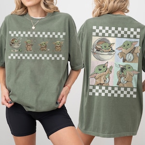 May include: Olive green t-shirt featuring a graphic of a character from a popular science fiction series. The front of the shirt shows the character in various poses with a checkered border. The back of the shirt has a similar design with the character in different scenes.