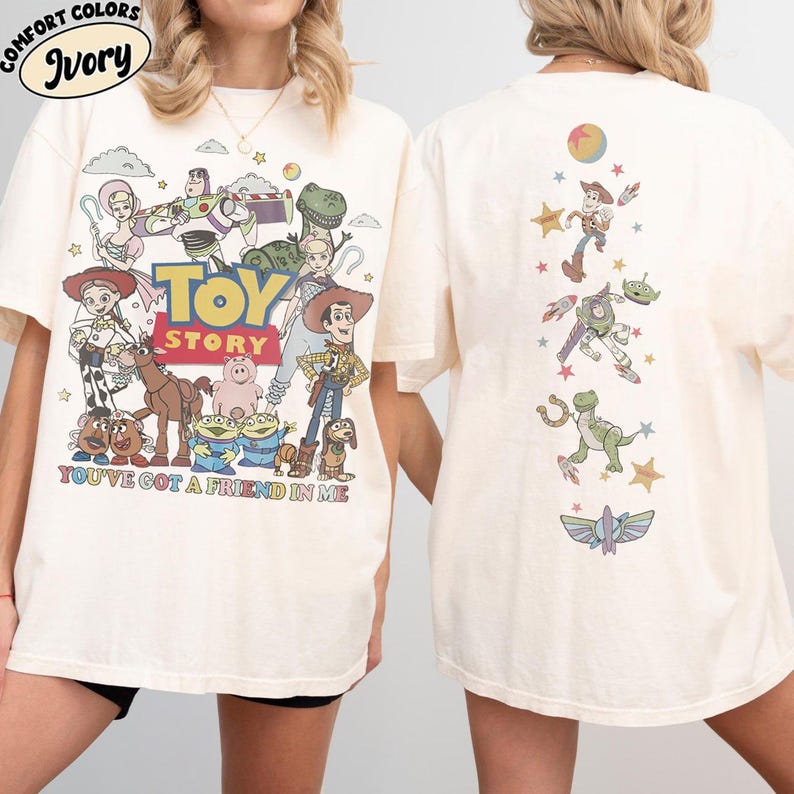 Op de afbeelding: Een ivoorkleurig t-shirt met Toy Story-personages op de voor- en achterkant. De voorkant toont een grote groep personages met het Toy Story-logo en de tekst You've Got A Friend In Me. De achterkant toont een verticale opstelling van figuren.