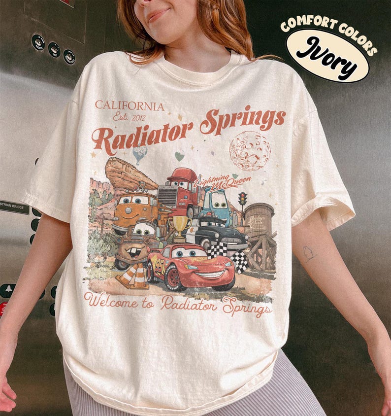 以下が含まれることがあります： 「Cars」のキャラクターのグラフィックがプリントされたアイボリー色のTシャツ。「California Est. 2012 Radiator Springs」と「Welcome to Radiator Springs」の文字入り。「Comfort Colors」のラベル付き。