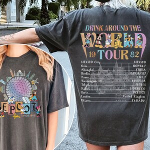 Może przedstawiać: Dwie czarne koszulki z vintage'owym wzorem. Prz&oacute;d jednej koszulki przedstawia kolorową ilustrację kuli Epcot z tekstem "EPCOT SINCE 1982". Tył drugiej koszulki przedstawia kolorową ilustrację Myszki Miki i jej przyjaci&oacute;ł z tekstem "DRINK AROUND THE WORLD 19 TOUR 82" i listą miast.