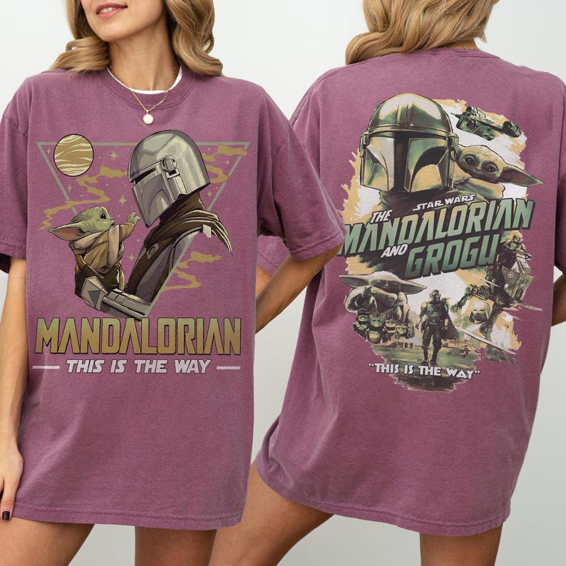 May include: A maroon t-shirt featuring a graphic of The Mandalorian and Grogu from Star Wars. The front design includes the text "MANDALORIAN" and "THIS IS THE WAY." The back design shows the Mandalorian helmet and Grogu with the text "THE MANDALORIAN AND GROGU."