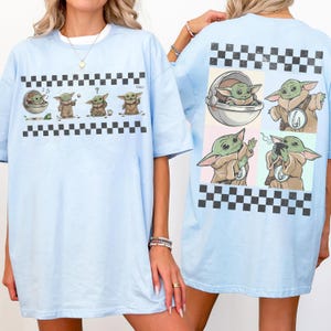 May include: Light blue t-shirts featuring a cartoon character in various poses, with a black and white checkered border. The front of the shirt shows four images of the character, while the back displays four different images of the character.