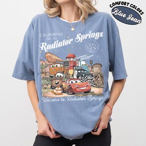 以下が含まれることがあります： ライトニング・マックィーンを含む、映画「カーズ」のキャラクターのグラフィックが特徴のブルーデニムカラーのTシャツ。「Radiator Springs」と「Welcome to Radiator Springs」の文字入り。コンフォートカラーズ素材。
