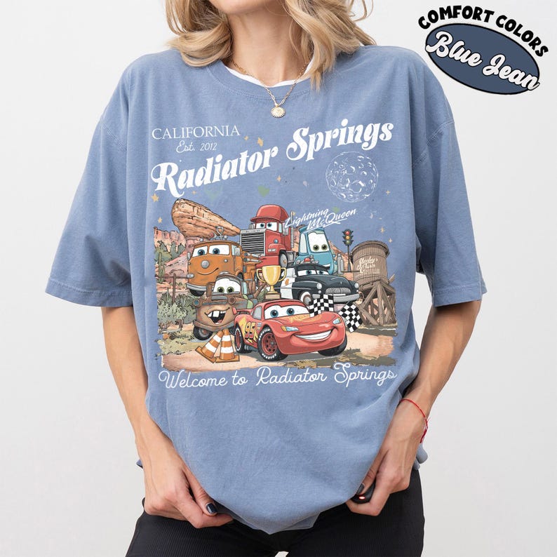 以下が含まれることがあります： ライトニング・マックィーンを含む、映画「カーズ」のキャラクターのグラフィックが特徴のブルーデニムカラーのTシャツ。「Radiator Springs」と「Welcome to Radiator Springs」の文字入り。コンフォートカラーズ素材。