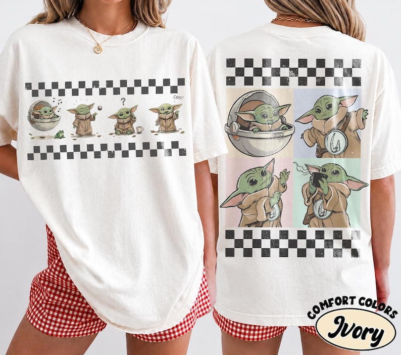 May include: Ivory-colored t-shirt featuring a graphic of a green alien character in various poses. The design includes a black and white checkered border. The shirt is labeled "Comfort Colors Ivory".