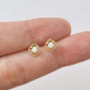 Könnte beinhalten: Eine weiße Keramik-Tasse mit schwarzem Henkel und dem Text "But First, Coffee" in schwarzer, handschriftlicher Schrift. Die Tasse steht auf einer weißen Oberfläche.