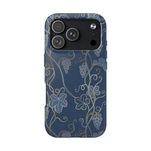 May include: A dark blue smartphone case featuring a repeating pattern of gold-outlined grape clusters and winding vine tendrils. The design covers the back of the case, which includes a rectangular cutout for a triple-lens camera system and flash.