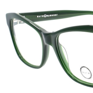 May include: Green cat-eye eyeglasses with a gold accent on the bridge.