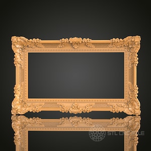 May include: A large, ornate, wooden picture frame with a detailed, carved design. The frame is a light brown color and has a rectangular shape.