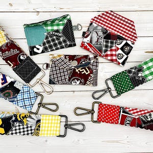 May include: A collection of patchwork fabric wristlets and wallets in various colors and patterns. The wristlets have metal clasps. The wallets have snap closures. The fabrics include polka dots, plaid, and team logos.